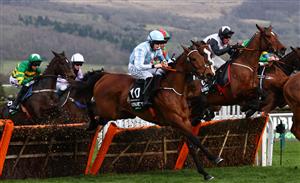 Jockey Rachael Blackmore (C) on hot favourite, Honeysuckle, jump a hurdle during the Champion Hurdle on the first day of the Cheltenham Festival at Cheltenham Racecourse, in Cheltenham, England on March 15, 2022. (Photo by Adrian DENNIS / AFP) (Photo by ADRIAN DENNIS/AFP via Getty Images)