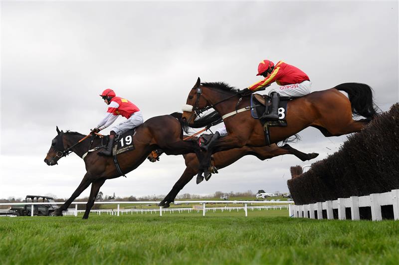 CHELTENHAM, ENGLAND - MARCH 17: Adam Wedge (R, red and yellow kit) on Coole Cody clear the third last in The Craft Irish Whiskey Co. Plate Handicap Chase race during day three of The Cheltenham Festival 2022 at Cheltenham Racecourse on March 17, 2022 in Cheltenham, England. (Photo by Mike Hewitt/Getty Images)