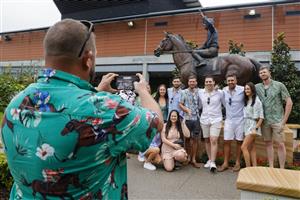 SYDNEY, AUSTRALIA - MARCH 19: Racegoers pose for a photo with the Winx and Hugh Bowman statue during Sydney Racing Longines Golden Slipper Day, at Rosehill Gardens on March 19, 2022 in Sydney, Australia. (Photo by Jenny Evans/Getty Images)