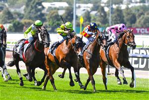MELBOURNE, AUSTRALIA - MARCH 19: Craig Williams riding Blandford Lad (L) winning Race 1, the Kennedy Grand Handicap Classic, during All-Star Mile Race day at Flemington Racecourse on March 19, 2022 in Melbourne, Australia. (Photo by Vince Caligiuri/Getty Images)