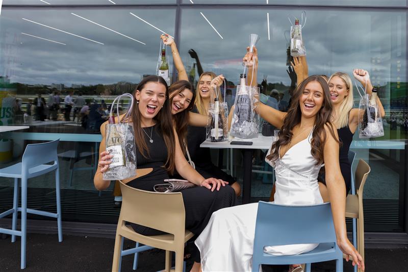 SYDNEY, AUSTRALIA - APRIL 02: Women with bottles of wine and sparkling pose for a photo during The Star Championships Day 1 at Royal Randwick Racecourse on April 02, 2022 in Sydney, Australia. The Championships race days are the highlight of the Sydney Autumn Racing Carnival. The Championships Day 1 features four Group 1 events headlined by the $3 million Doncaster Mile and $2 million Australian Derby. (Photo by Jenny Evans/Getty Images)
