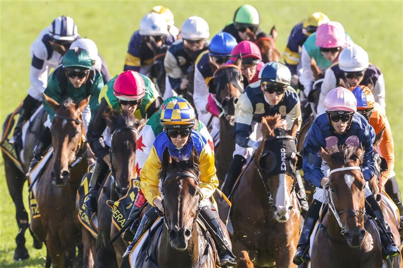 SYDNEY, AUSTRALIA - APRIL 09: Rachel King (yellow and blue checked cap) on Knights Order rounds the first circut to win race 7 the Schweppes Sydney Cup during The Championships Day 2, Longines Queen Elizabeth Stakes Day, at Royal Randwick Racecourse on April 09, 2022 in Sydney, Australia. (Photo by Jenny Evans/Getty Images)