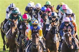 SYDNEY, AUSTRALIA - APRIL 09: Rachel King (yellow and blue checked cap) on Knights Order rounds the first circut to win race 7 the Schweppes Sydney Cup during The Championships Day 2, Longines Queen Elizabeth Stakes Day, at Royal Randwick Racecourse on April 09, 2022 in Sydney, Australia. (Photo by Jenny Evans/Getty Images)