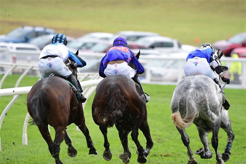 WARRNAMBOOL, AUSTRALIA - MAY 04: Steven Pateman riding Saunter Boy (r) races to win from Will Gordon riding St Arnicca and Lee Horner riding Out and Dreaming (L) before winning Race 6, the Sovereign Resort Galleywood Hurdle, during Galleywood Hurdle day at Warrnambool Racing Club on May 04, 2022 in Warrnambool, Australia. (Photo by Vince Caligiuri/Getty Images)