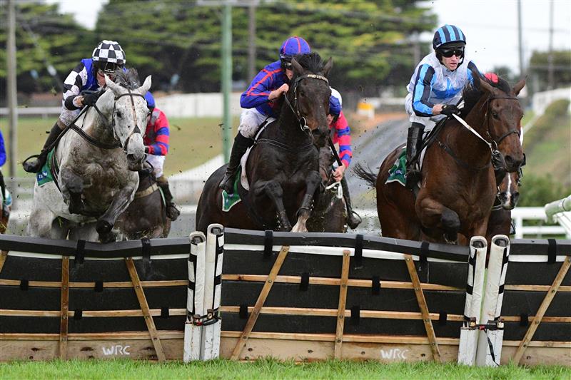 WARRNAMBOOL, AUSTRALIA - MAY 04: Steven Pateman riding Saunter Boy (L) jumps the second last jump with Will Gordon riding St Arnicca and Lee Horner riding Out and Dreaming (r) before winning Race 6, the Sovereign Resort Galleywood Hurdle, during Galleywood Hurdle day at Warrnambool Racing Club on May 04, 2022 in Warrnambool, Australia. (Photo by Vince Caligiuri/Getty Images)