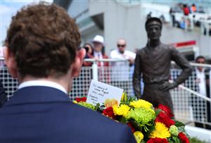 EPSOM, ENGLAND - JUNE 03: Jockey Ryan Moore prepares to lay at wreath at the base of the Lester Piggott statue following Piggott's recent passing during Ladies Day at Epsom Racecourse on June 03, 2022 in Epsom, England. (Photo by Andrew Redington/Getty Images)