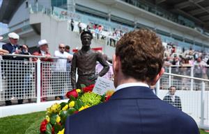 EPSOM, ENGLAND - JUNE 03: Jockey Ryan Moore prepares to lay at wreath at the base of the Lester Piggott statue following Piggott's recent passing during Ladies Day at Epsom Racecourse on June 03, 2022 in Epsom, England. (Photo by Andrew Redington/Getty Images)