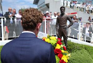 EPSOM, ENGLAND - JUNE 03: Jockey Ryan Moore prepares to lay at wreath at the base of the Lester Piggott statue following Piggott's recent passing during Ladies Day at Epsom Racecourse on June 03, 2022 in Epsom, England. (Photo by Andrew Redington/Getty Images)