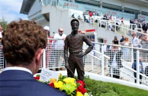 EPSOM, ENGLAND - JUNE 03: Jockey Ryan Moore prepares to lay at wreath at the base of the Lester Piggott statue following Piggott's recent passing during Ladies Day at Epsom Racecourse on June 03, 2022 in Epsom, England. (Photo by Andrew Redington/Getty Images)