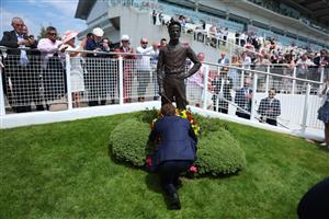 EPSOM, ENGLAND - JUNE 03: Jockey Ryan Moore lays a wreath at the base of the Lester Piggott statue following Piggott's recent passing during Ladies Day at Epsom Racecourse on June 03, 2022 in Epsom, England. (Photo by Andrew Redington/Getty Images)