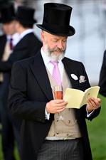 ASCOT, ENGLAND - JUNE 14: A racegoer reads the Offical Ascot Programme during Royal Ascot 2022 at Ascot Racecourse on June 14, 2022 in Ascot, England. (Photo by Eamonn M. McCormack/Getty Images for Ascot Racecourse)