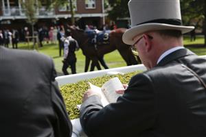 ASCOT, ENGLAND - JUNE 15: A racegoer reading the official programme during Royal Ascot 2022 at Ascot Racecourse on June 15, 2022 in Ascot, England. (Photo by John Phillips/Getty Images for Ascot Racecourse)
