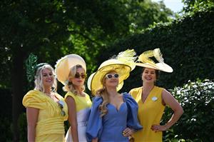 Race-goers pose upon their arrival to attend the third day, known as the Lady