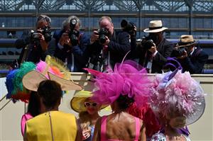 TOPSHOT - Race-goers wearing hats speak together as they are photographed during the third day, known as the Lady