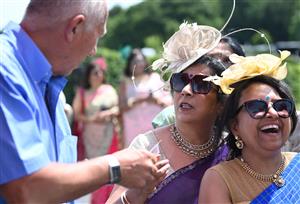 ASCOT, ENGLAND - JUNE 16: Racegoers wearing sarees place bets during Royal Ascot 2022 at Ascot Racecourse on June 16, 2022 in Ascot, England. (Photo by Eamonn M. McCormack/Getty Images for Ascot Racecourse)