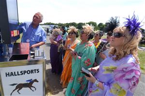 ASCOT, ENGLAND - JUNE 16: Racegoers wearing sarees place bets during Royal Ascot 2022 at Ascot Racecourse on June 16, 2022 in Ascot, England. (Photo by Eamonn M. McCormack/Getty Images for Ascot Racecourse)