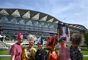 Racegoers pose for a photograph beside the winner