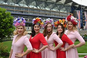 Racegoers pose for a photograph beside the winner