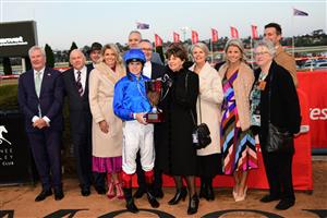 MELBOURNE, AUSTRALIA - JULY 30: Craig Williams poses with his mother Glenda and members of the Harrison family after riding Lackeen in Race 8, the Ranvet Travis Harrison Cup, during Melbourne Racing at Moonee Valley Racecourse on July 30, 2022 in Melbourne, Australia. (Photo by Vince Caligiuri/Getty Images)