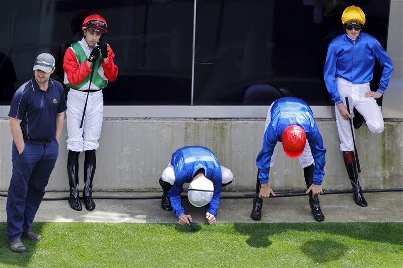 SYDNEY, AUSTRALIA - OCTOBER 22: Jockeys stretch and wait to mount up ahead of race 2 during Spring Champions Stakes Day at Royal Randwick Racecourse on October 22, 2022 in Sydney, Australia. (Photo by Jenny Evans/Getty Images)