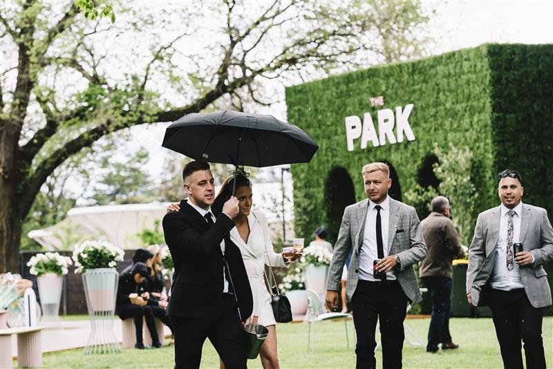 MELBOURNE, AUSTRALIA - OCTOBER 29: Punters take cover from the rain at The Park, during 2022 Penfolds Victoria Derby Day at Flemington Racecourse on October 29, 2022 in Melbourne, Australia. (Photo by Naomi Rahim/Getty Images for VRC)