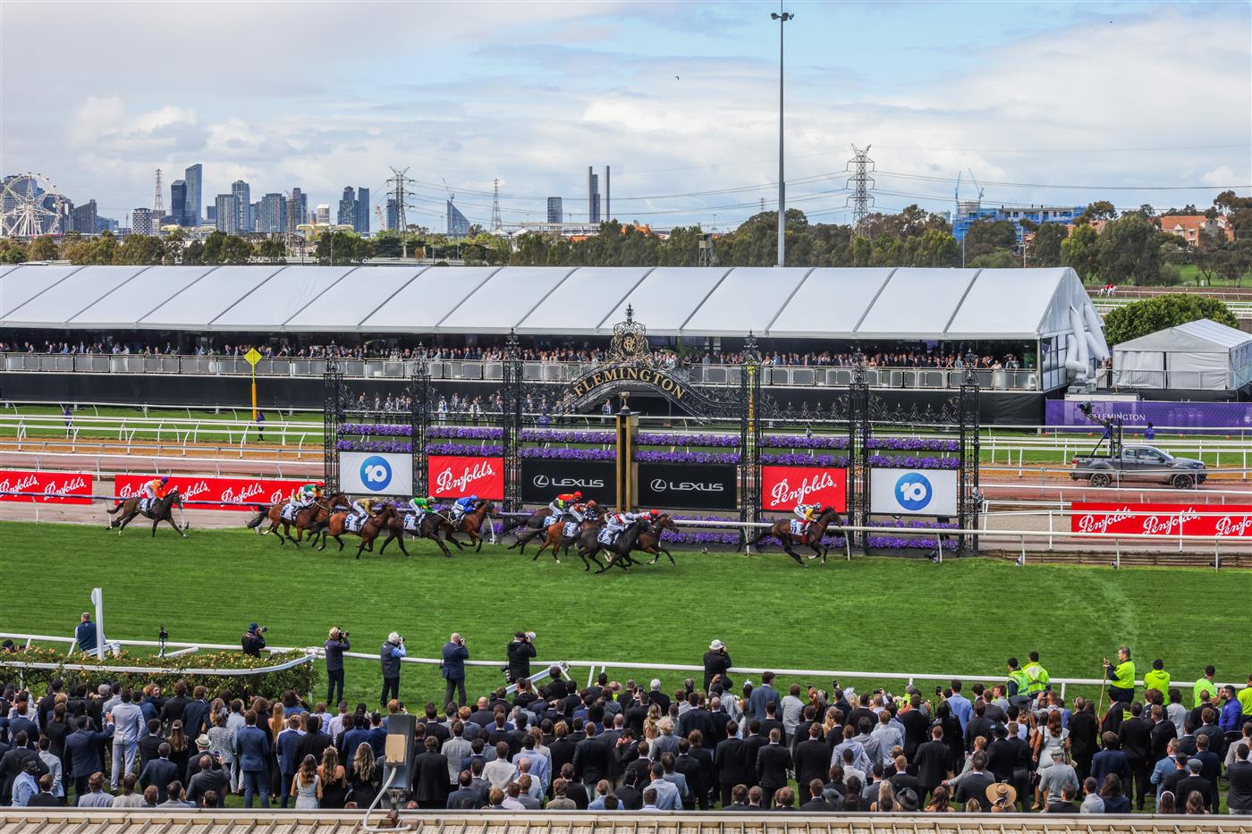 MELBOURNE, AUSTRALIA - OCTOBER 29: Spectators look as as horses approach the finishing line in race 1 the Carbine Club Stakes during 2022 AAMI Victoria Derby Day at Flemington Racecourse on October 29, 2022 in Melbourne, Australia. (Photo by Asanka Ratnayake/Getty Images)