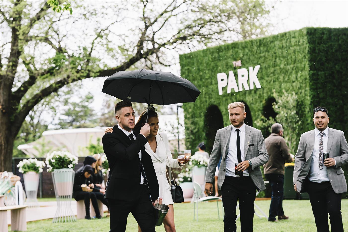 MELBOURNE, AUSTRALIA - OCTOBER 29: Punters take cover from the rain at The Park, during 2022 Penfolds Victoria Derby Day at Flemington Racecourse on October 29, 2022 in Melbourne, Australia. (Photo by Naomi Rahim/Getty Images for VRC)