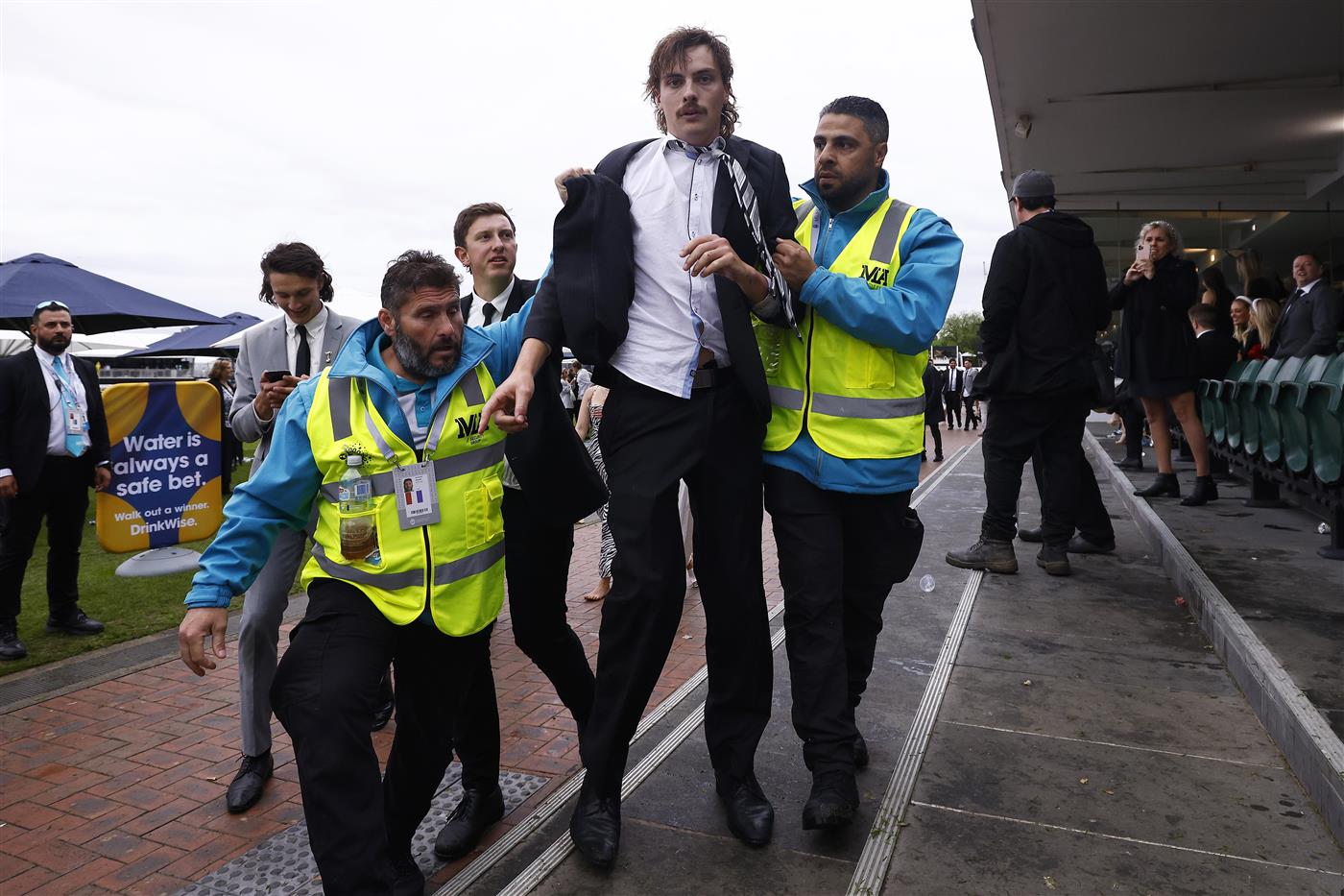 MELBOURNE, AUSTRALIA - OCTOBER 29: Police and security attempt to break up a large crowd of racegoers for unsocial behaviour after the final race during 2022 Penfolds Victoria Derby Day at Flemington Racecourse on October 29, 2022 in Melbourne, Australia. (Photo by Daniel Pockett/Getty Images)
