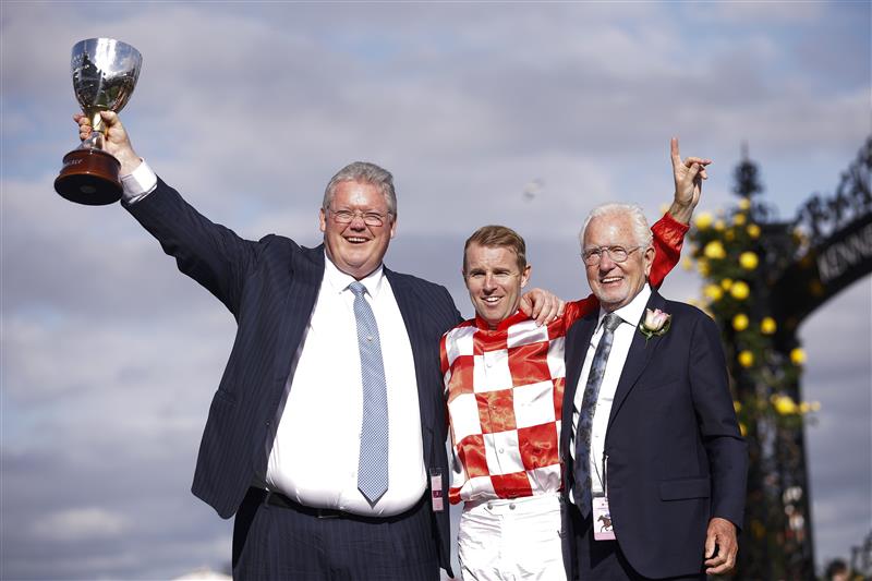 MELBOURNE, AUSTRALIA - NOVEMBER 03: (L-R) Trainer Anthony Cummings, Tommy Berry, and owner Robert Crabtree pose with the Kennedy trophy.