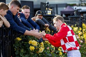 MELBOURNE, AUSTRALIA - NOVEMBER 03: Jockey Tommy Berry signs a pair of goggles during 2022 Oaks Day at Flemington Racecourse on November 03, 2022 in Melbourne, Australia. (Photo by Luke Hemer/Getty Images for VRC)