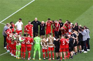Wales players and coaches huddle after the loss (Getty Images)