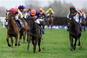 NEWBURY, ENGLAND - NOVEMBER 26: Harry Skelton riding Le Milos (orange cap) clear the last to win The Coral Gold Cup Handicap Chase at Newbury Racecourse on November 26, 2022 in Newbury, England. (Photo by Alan Crowhurst/Getty Images)