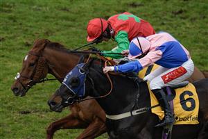ESHER, ENGLAND - MARCH 11: Jamie Moore riding Hudson De Grugy (pink) clear the last to win The Betfair Daily Multiples Offer At Cheltenham Novices' Handicap Chase from Harry Cobden and Quel Destin at Sandown Park on March 11, 2023 in Esher, England. (Photo by Alan Crowhurst/Getty Images)
