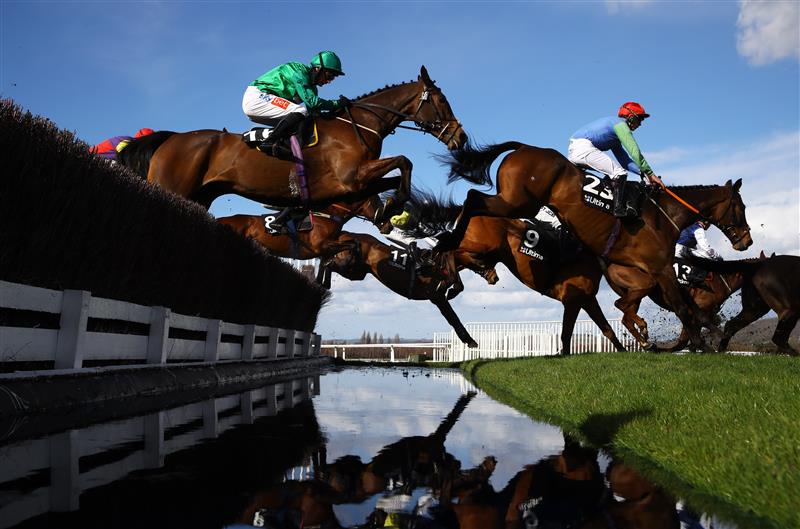 CHELTENHAM, ENGLAND - MARCH 14: Runners take the water jump during the Ultima Handicap Chase during day one of the Cheltenham Festival 2023 at Cheltenham Racecourse on March 14, 2023 in Cheltenham, England. (Photo by Michael Steele/Getty Images)