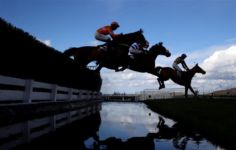 CHELTENHAM, ENGLAND - MARCH 14: Runners take the water jump during the Ultima Handicap Chase during day one of the Cheltenham Festival 2023 at Cheltenham Racecourse on March 14, 2023 in Cheltenham, England. (Photo by Michael Steele/Getty Images)