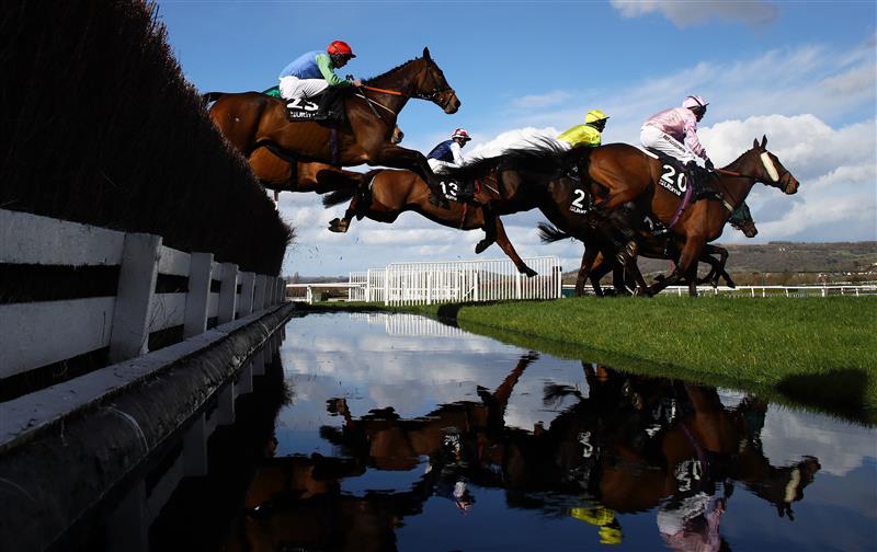 CHELTENHAM, ENGLAND - MARCH 14: Runners take the water jump during the Ultima Handicap Chase during day one of the Cheltenham Festival 2023 at Cheltenham Racecourse on March 14, 2023 in Cheltenham, England. (Photo by Michael Steele/Getty Images)