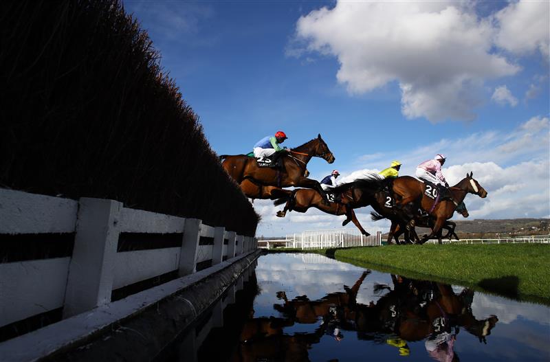 CHELTENHAM, ENGLAND - MARCH 14: Runners take the water jump during the Ultima Handicap Chase during day one of the Cheltenham Festival 2023 at Cheltenham Racecourse on March 14, 2023 in Cheltenham, England. (Photo by Michael Steele/Getty Images)