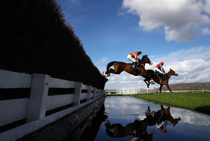 CHELTENHAM, ENGLAND - MARCH 14: Runners take the water jump during the Ultima Handicap Chase during day one of the Cheltenham Festival 2023 at Cheltenham Racecourse on March 14, 2023 in Cheltenham, England. (Photo by Michael Steele/Getty Images)