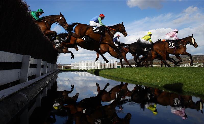 CHELTENHAM, ENGLAND - MARCH 14: Runners take the water jump during the Ultima Handicap Chase during day one of the Cheltenham Festival 2023 at Cheltenham Racecourse on March 14, 2023 in Cheltenham, England. (Photo by Michael Steele/Getty Images)
