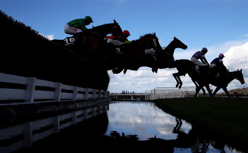 CHELTENHAM, ENGLAND - MARCH 14: Runners take the water jump during the Ultima Handicap Chase during day one of the Cheltenham Festival 2023 at Cheltenham Racecourse on March 14, 2023 in Cheltenham, England. (Photo by Michael Steele/Getty Images)