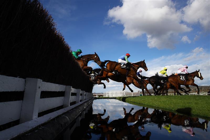 CHELTENHAM, ENGLAND - MARCH 14: Runners take the water jump during the Ultima Handicap Chase during day one of the Cheltenham Festival 2023 at Cheltenham Racecourse on March 14, 2023 in Cheltenham, England. (Photo by Michael Steele/Getty Images)