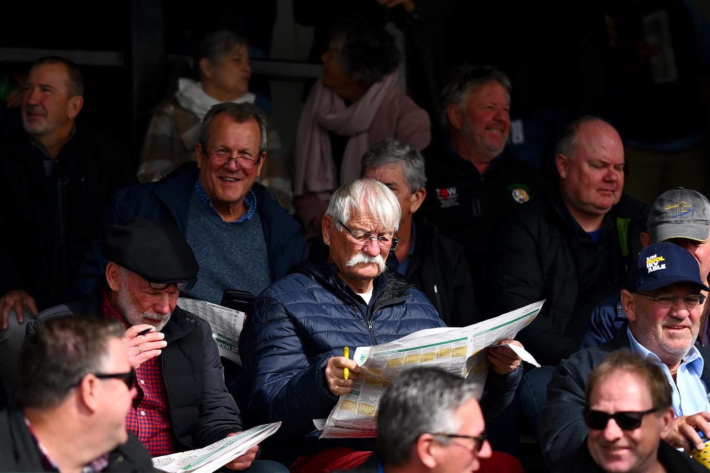WARRNAMBOOL, AUSTRALIA - MAY 03: Punters prepare for a race in a grand stand during Galleywood Hurdle day at Warrnambool Racing Club on May 03, 2023 in Warrnambool, Australia. (Photo by Morgan Hancock/Getty Images)