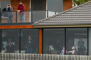 WARRNAMBOOL, AUSTRALIA - MAY 04: Crowds watch the Brandt Grand Annual Steeplechase from a home during Grand Annual Day at Warrnambool Racing Club on May 04, 2023 in Warrnambool, Australia. (Photo by Morgan Hancock/Getty Images)