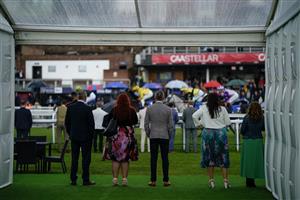 CHESTER, ENGLAND - MAY 10: Racegoers watch the racing undercover as the runner pass at Chester Racecourse on May 10, 2023 in Chester, England. (Photo by Alan Crowhurst/Getty Images)