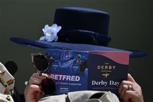 A racegoer consults her racecard ahead of racing on the second day of the Epsom Derby Festival horse racing event in Surrey, southern England on June 3, 2023. (Photo by Ben Stansall / AFP) (Photo by BEN STANSALL/AFP via Getty Images)