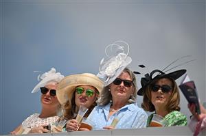 Racegoers enjoy a drink in the sunshine ahead of racing on the second day of the Epsom Derby Festival horse racing event in Surrey, southern England on June 3, 2023. (Photo by Ben Stansall / AFP) (Photo by BEN STANSALL/AFP via Getty Images)