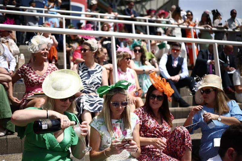 Racegoers enjoy a drink in the summer sunshine ahead of racing on the fourth day of the Royal Ascot horse racing meeting in Ascot, west of London, on June 23, 2023. (Photo by HENRY NICHOLLS / AFP) (Photo by HENRY NICHOLLS/AFP via Getty Images)