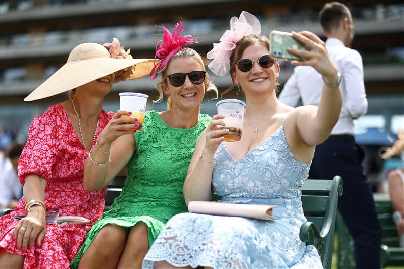 Racegoers take a selfie-photograph ahead of racing on the fourth day of the Royal Ascot horse racing meeting in Ascot, west of London, on June 23, 2023. (Photo by HENRY NICHOLLS / AFP) (Photo by HENRY NICHOLLS/AFP via Getty Images)