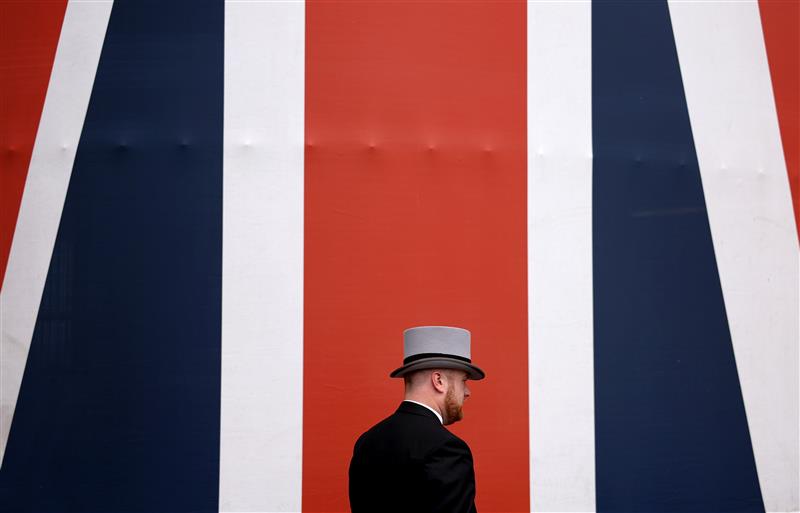 ASCOT, ENGLAND - JUNE 24: A racegoer walks past a British Flag during day five of Royal Ascot 2023 at Ascot Racecourse on June 24, 2023 in Ascot, England. (Photo by Alex Pantling/Getty Images)