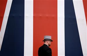 ASCOT, ENGLAND - JUNE 24: A racegoer walks past a British Flag during day five of Royal Ascot 2023 at Ascot Racecourse on June 24, 2023 in Ascot, England. (Photo by Alex Pantling/Getty Images)